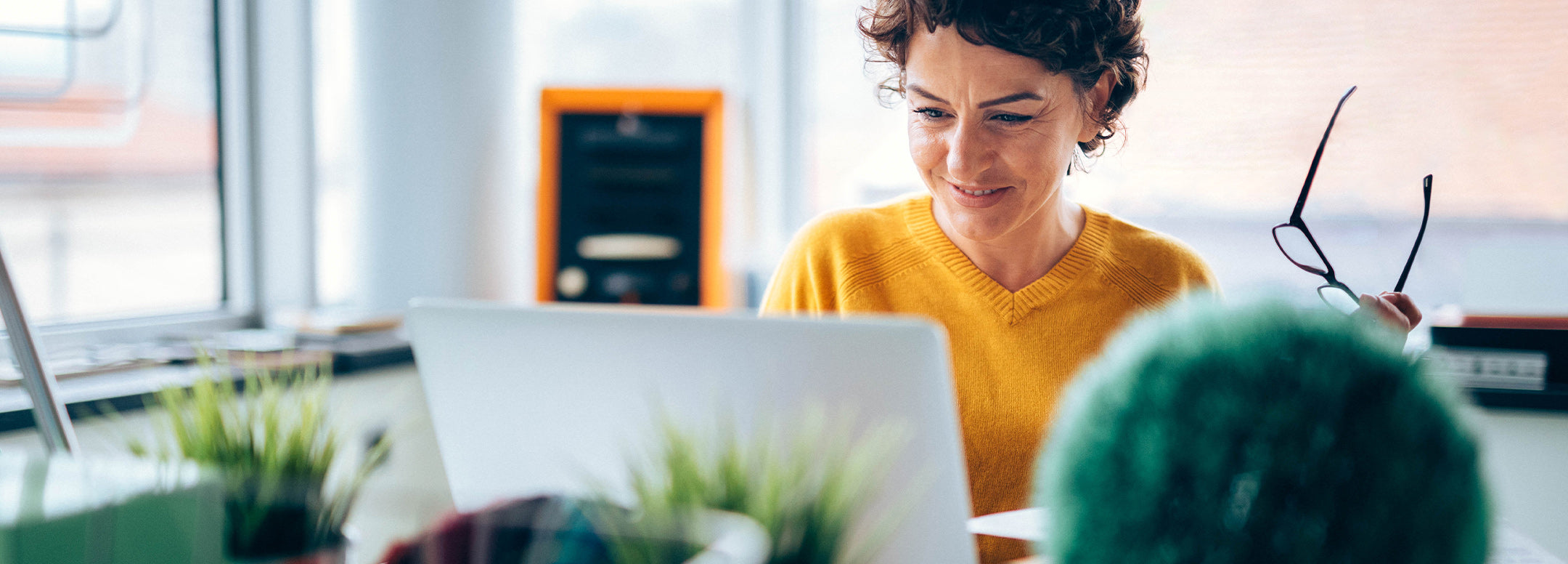 Happy middle-aged woman looking at computer at www.prevagen.com