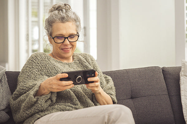 Woman on couch playing a hand-held game