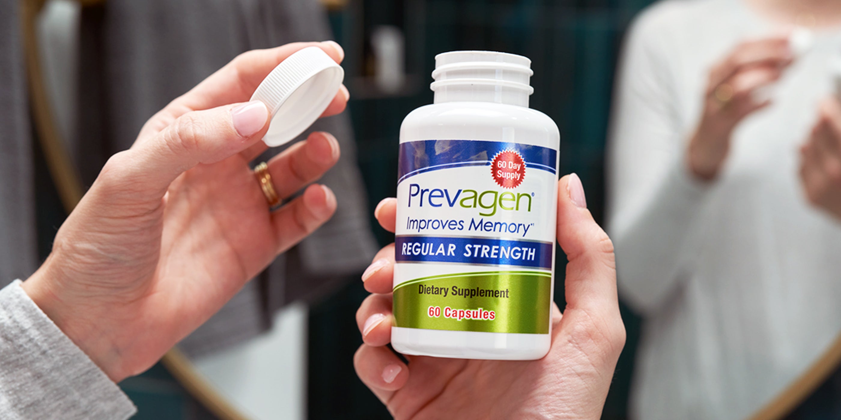 Bottle of Prevagen regular strength 60 day supply held by woman at bathroom counter