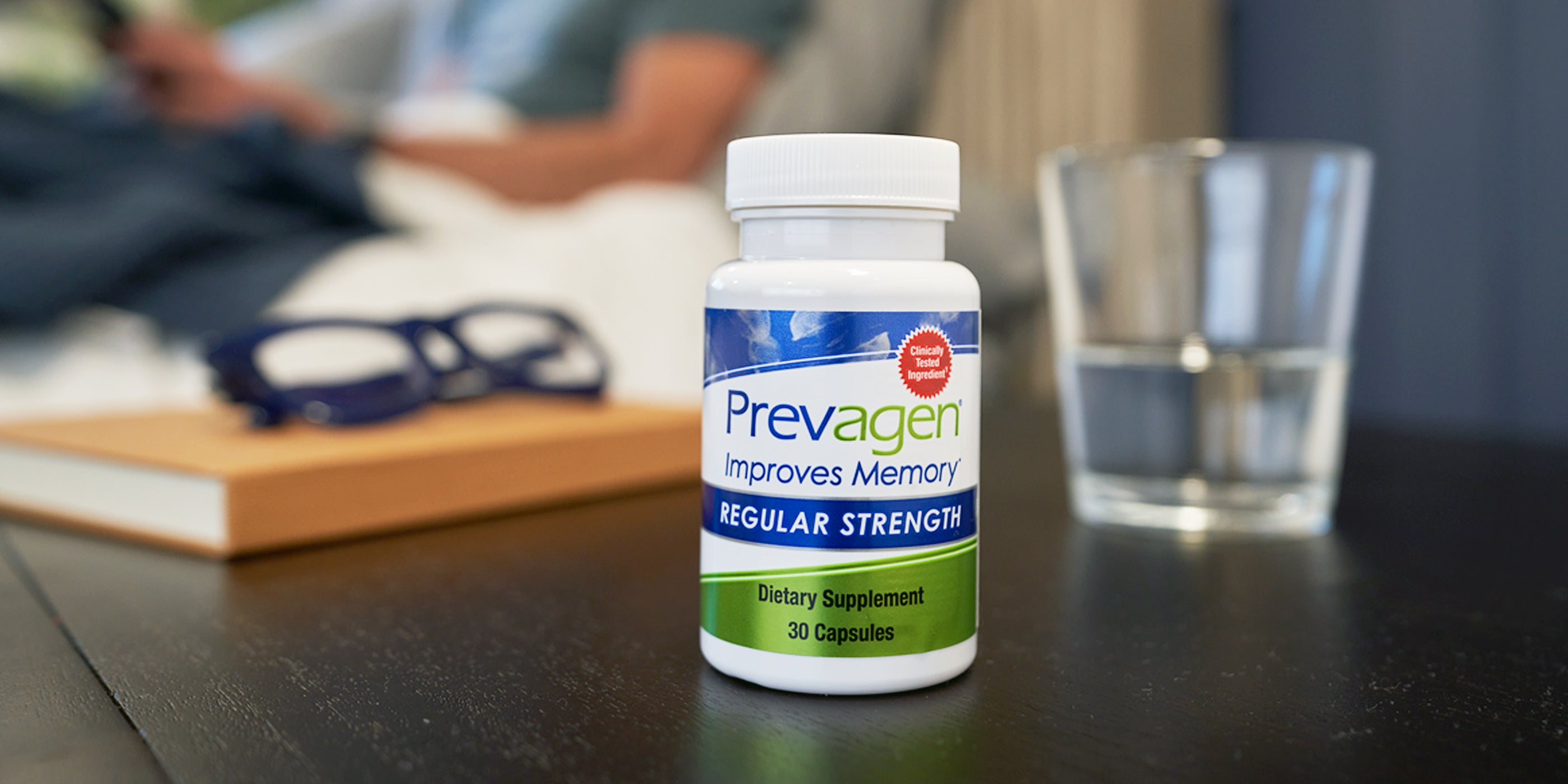 Bottle of Regular Strength Prevagen capsules on a bedside table